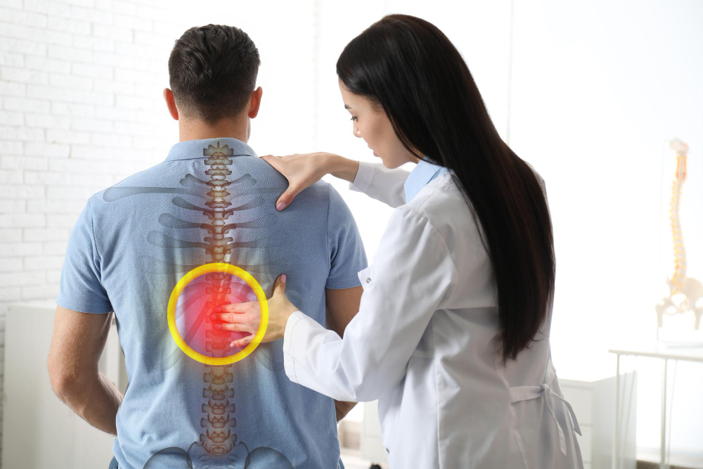 Chiropractor examining a patient’s spine to provide poor posture injury relief in Brooklyn.