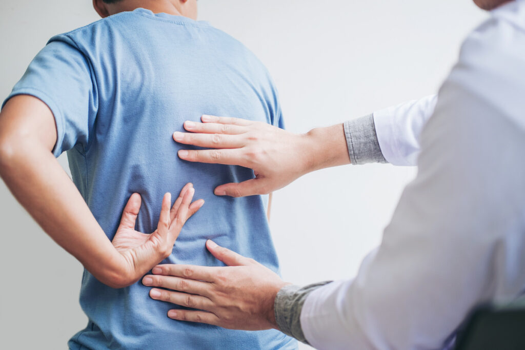 Chiropractic evaluation after car accidents showing chiropractor assessing patient lower back pain in Brooklyn NY
