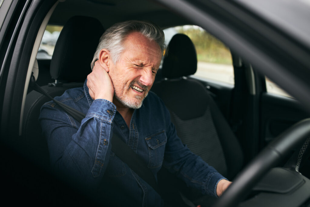 Driver experiencing neck pain and whiplash after a car crash treated with chiropractic therapy for whiplash at Back In Motion Group Brooklyn NY
