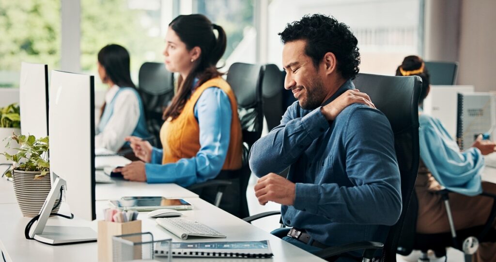Office worker experiencing shoulder pain from repetitive stress injury at workstation covered under workers comp chiropractic care at Back In Motion Group Brooklyn NY