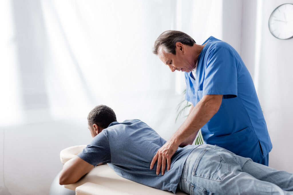 Workers comp chiropractor performing lumbar spine evaluation on injured worker at Back In Motion Group Brooklyn NY